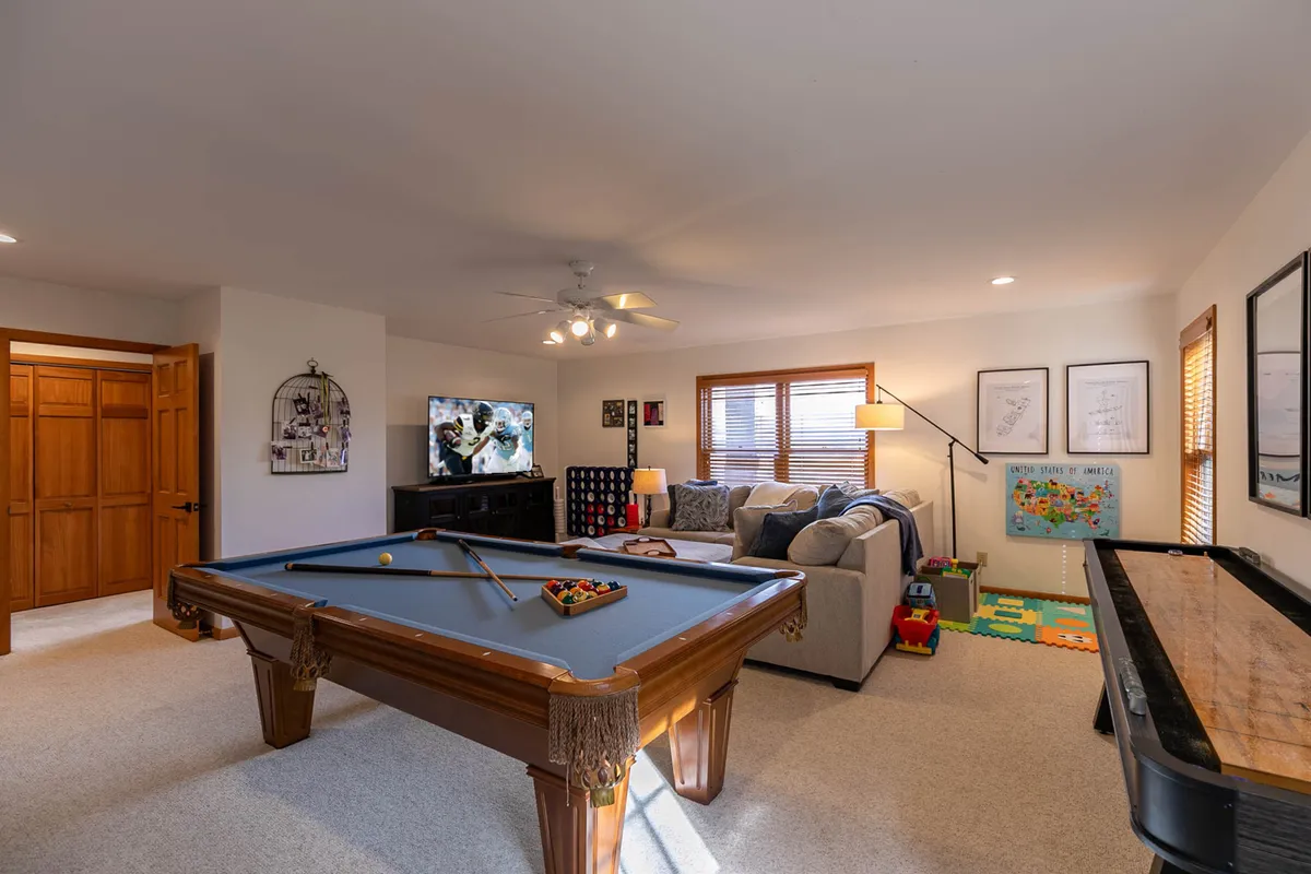 A playful interior featuring a pool table, couch, television, and piano, creating the perfect atmosphere for après-ski relaxation and entertainment. The scene is lively and welcoming, suggesting a hub for post-slope festivities and bonding.